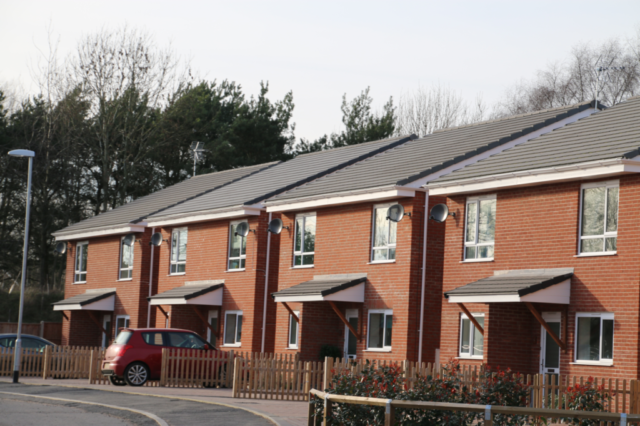 A line of new build houses with pitched tiled roofs